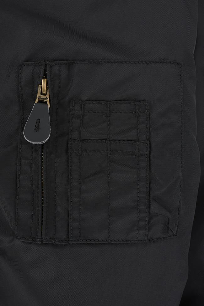 Schwarze Brandit CWU Fliegerjacke mit warmem Teddyfell, gefütterter Kapuze, Strickbündchen und wind-/wasserabweisendem Nylon.