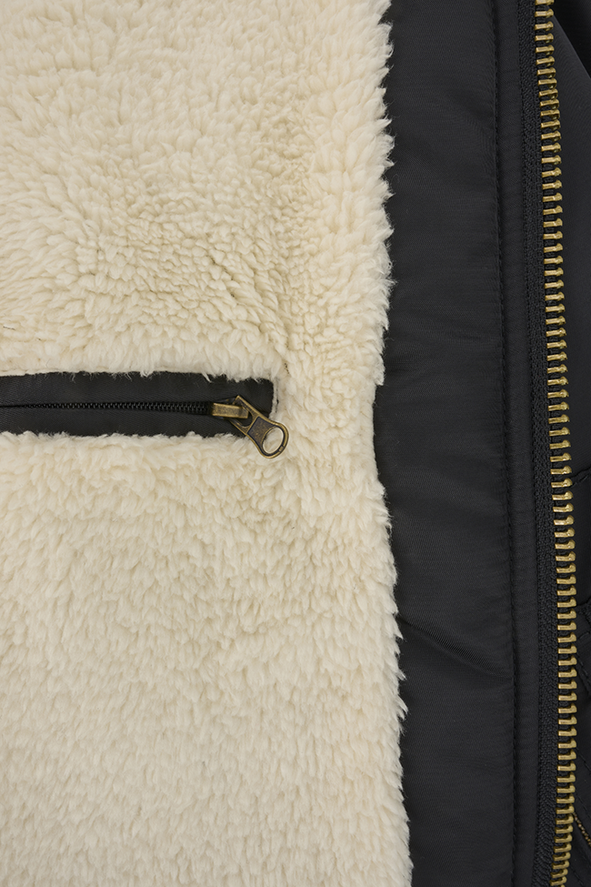 Schwarze Brandit CWU Fliegerjacke mit warmem Teddyfell, gefütterter Kapuze, Strickbündchen und wind-/wasserabweisendem Nylon.