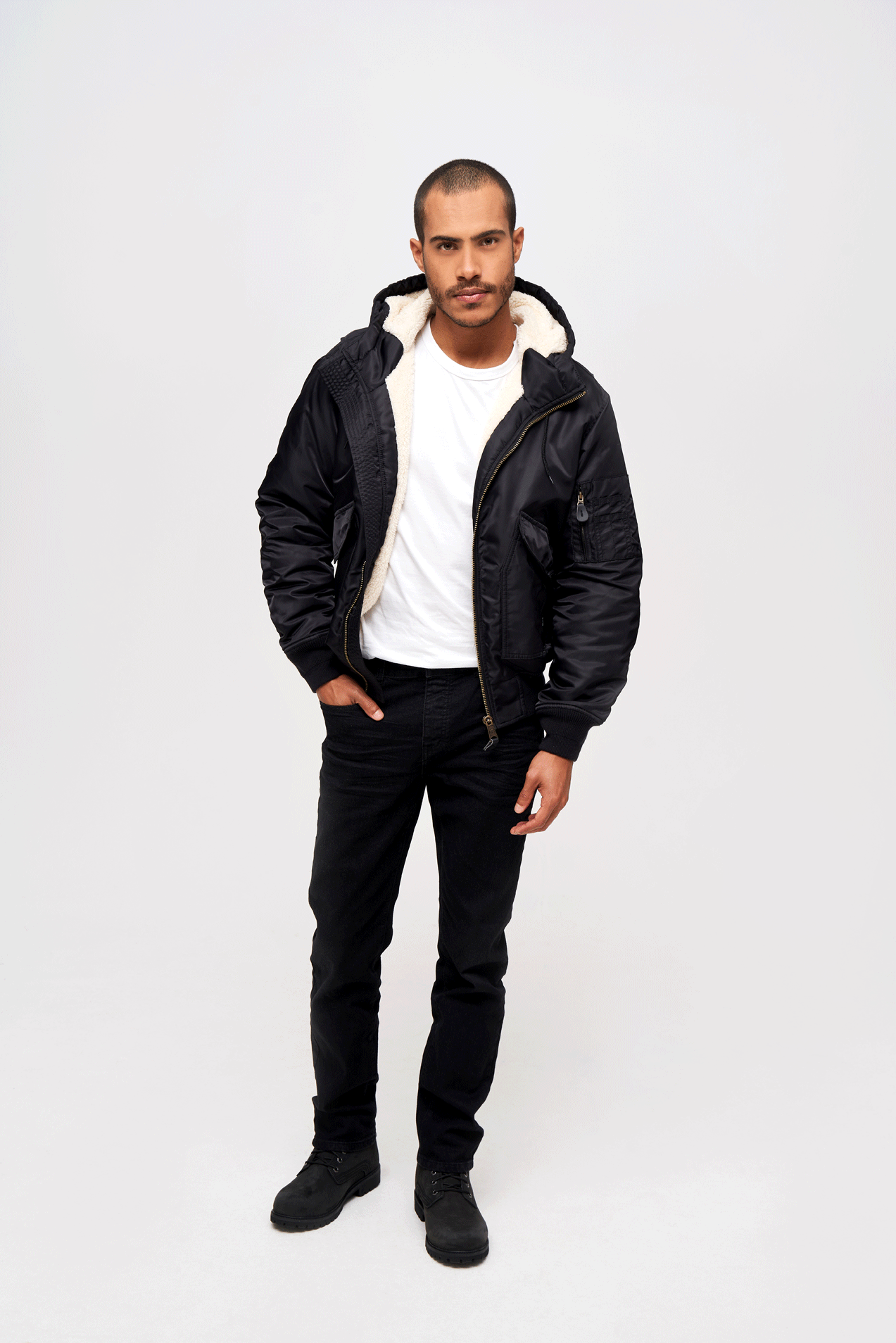 Schwarze Brandit CWU Fliegerjacke mit warmem Teddyfell, gefütterter Kapuze, Strickbündchen und wind-/wasserabweisendem Nylon.