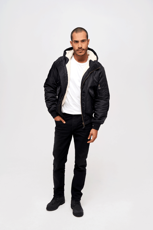 Schwarze Brandit CWU Fliegerjacke mit warmem Teddyfell, gefütterter Kapuze, Strickbündchen und wind-/wasserabweisendem Nylon.