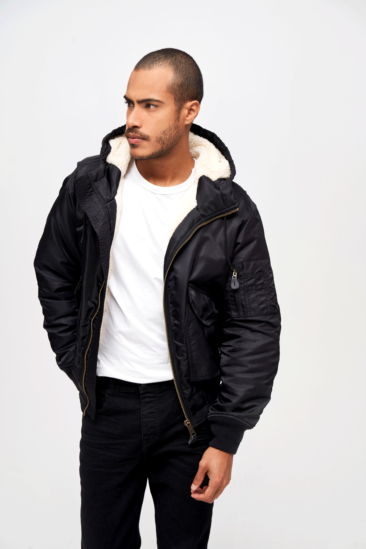 Schwarze Brandit CWU Fliegerjacke mit warmem Teddyfell, gefütterter Kapuze, Strickbündchen und wind-/wasserabweisendem Nylon.
