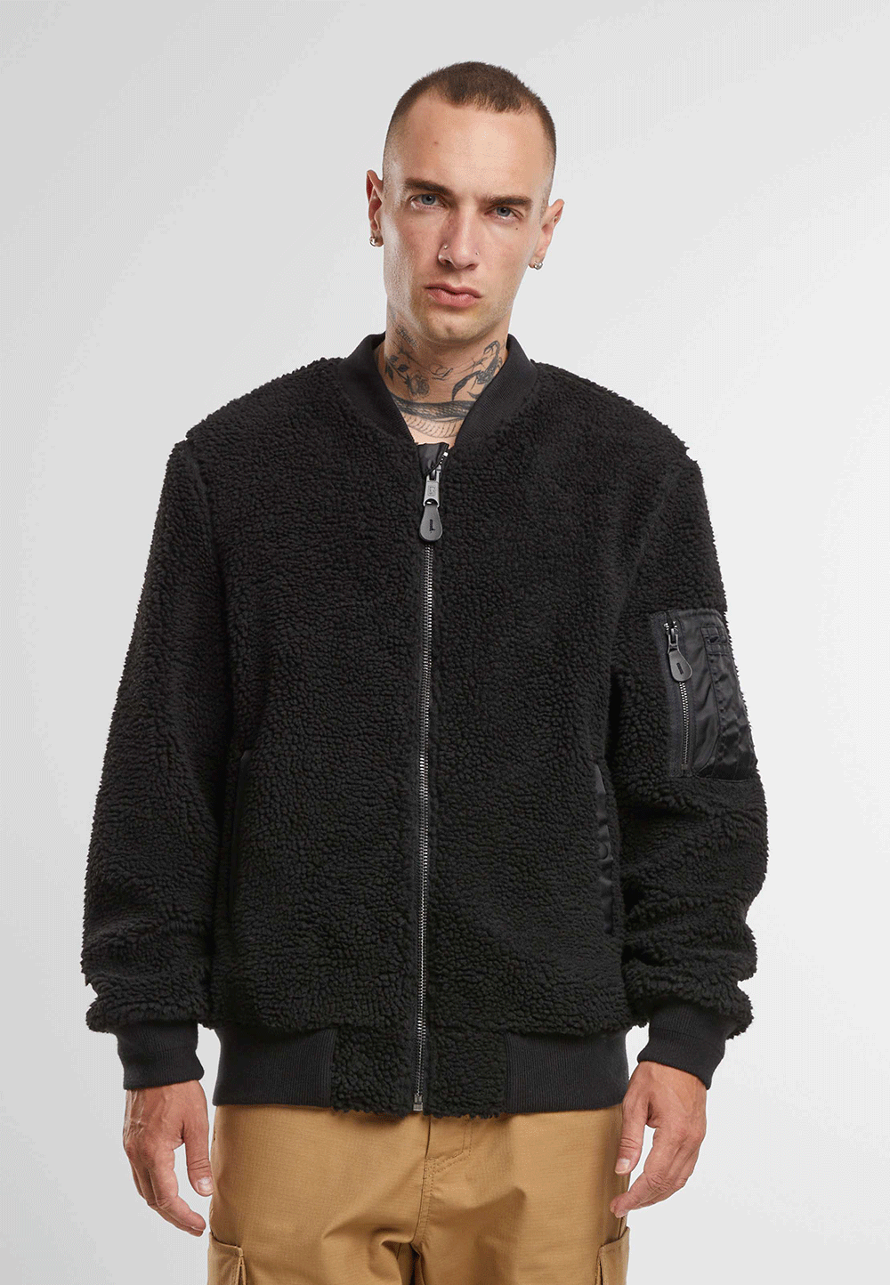 Brandit Teddyfleece-Bomberjacke in Schwarz mit Strickbund, zwei Einschubtaschen und Oberarmtasche mit Reissverschluss.