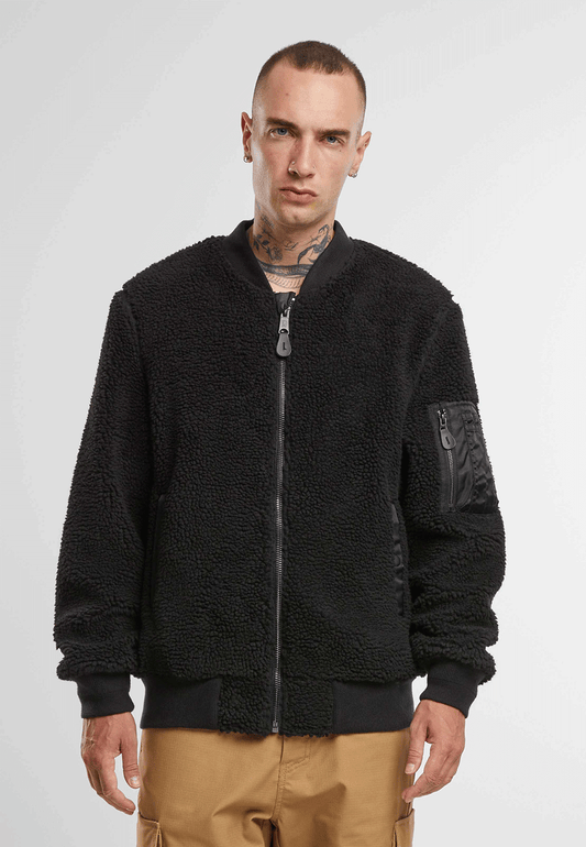 Brandit Teddyfleece-Bomberjacke in Schwarz mit Strickbund, zwei Einschubtaschen und Oberarmtasche mit Reissverschluss.