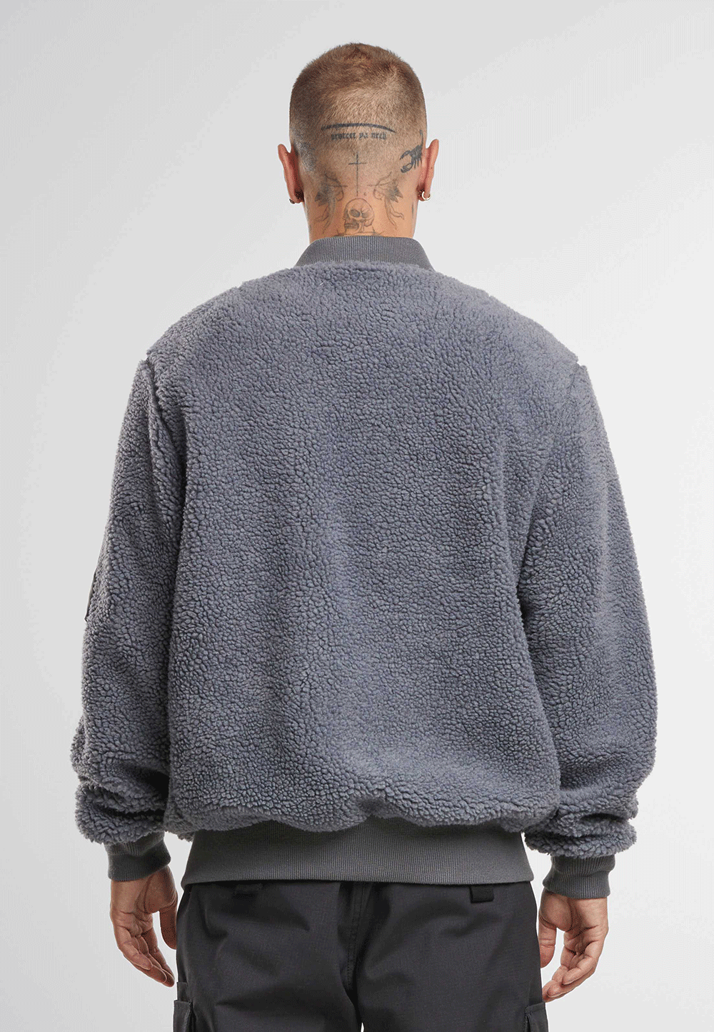 Brandit Teddyfleece-Bomberjacke in Anthra mit Strickbund, zwei Einschubtaschen und Oberarmtasche mit Reissverschluss.