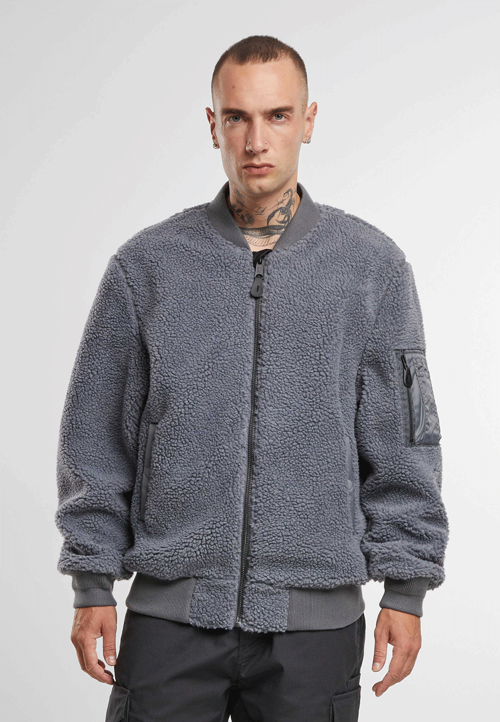 Brandit Teddyfleece-Bomberjacke in Anthra mit Strickbund, zwei Einschubtaschen und Oberarmtasche mit Reissverschluss.
