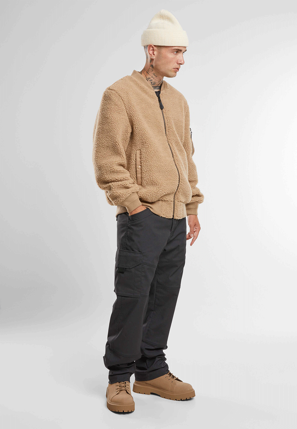 Brandit Teddyfleece-Bomberjacke in Camel mit Strickbund, zwei Einschubtaschen und Oberarmtasche mit Reissverschluss.