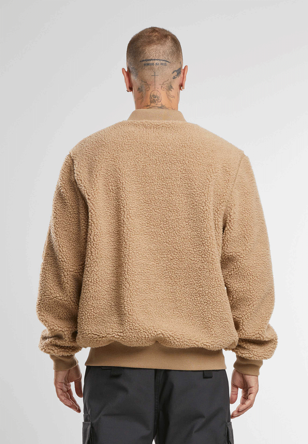 Brandit Teddyfleece-Bomberjacke in Camel mit Strickbund, zwei Einschubtaschen und Oberarmtasche mit Reissverschluss.