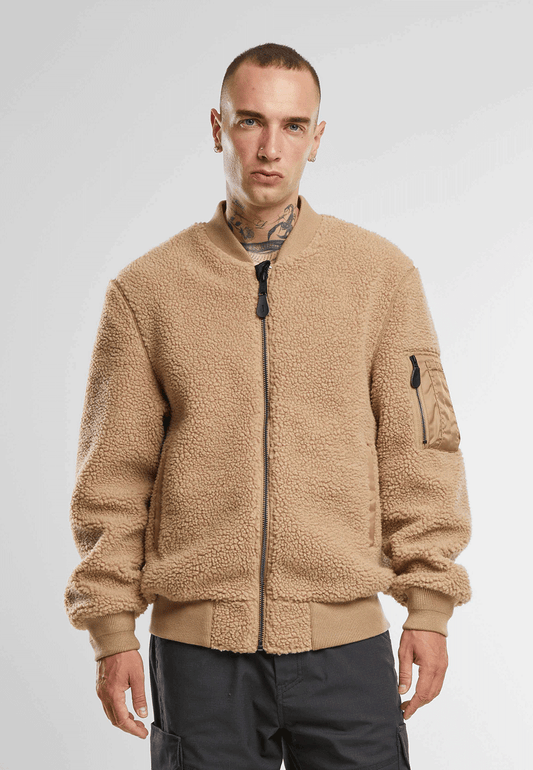 Brandit Teddyfleece-Bomberjacke in Camel mit Strickbund, zwei Einschubtaschen und Oberarmtasche mit Reissverschluss.