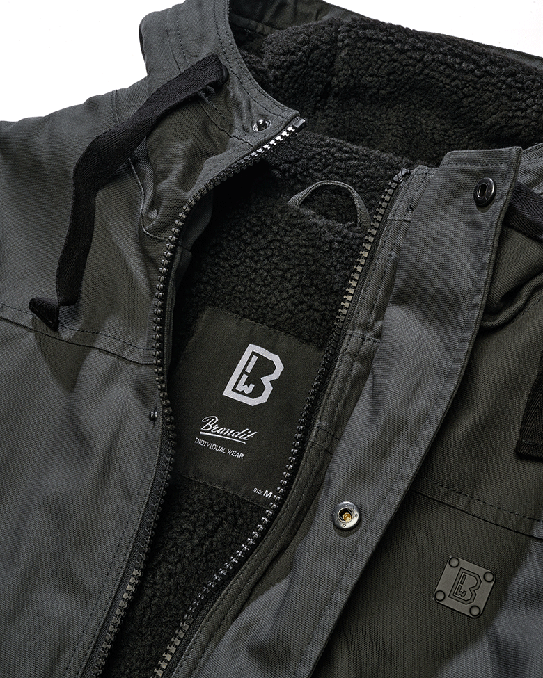 Brandit Kurzjacke Anthracite aus robustem Canvas mit Kapuze, Kordelzug, Teddyfellfutter und praktischen Taschen.