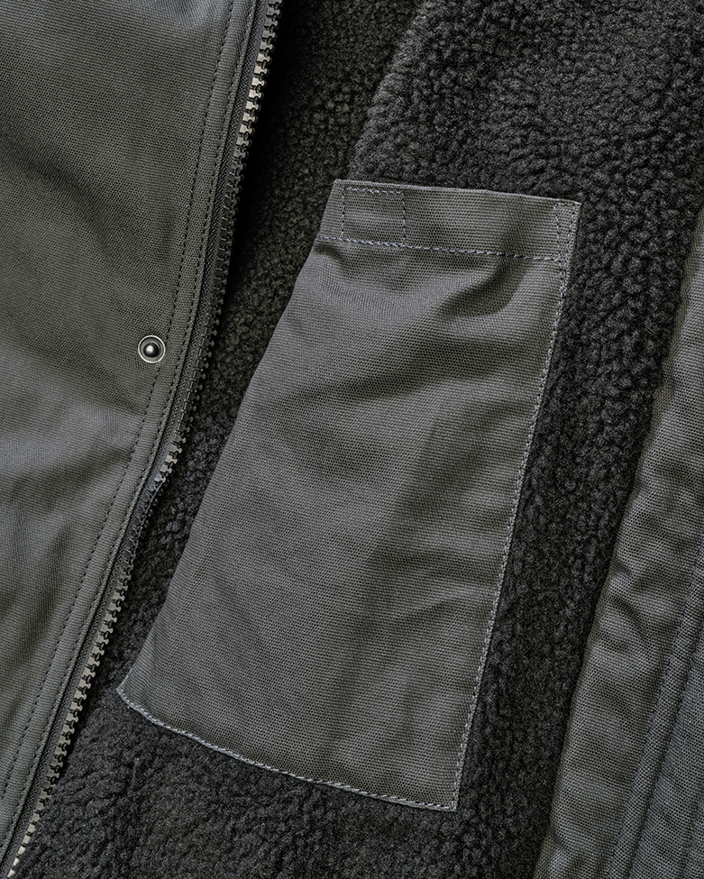 Brandit Kurzjacke Anthracite aus robustem Canvas mit Kapuze, Kordelzug, Teddyfellfutter und praktischen Taschen.