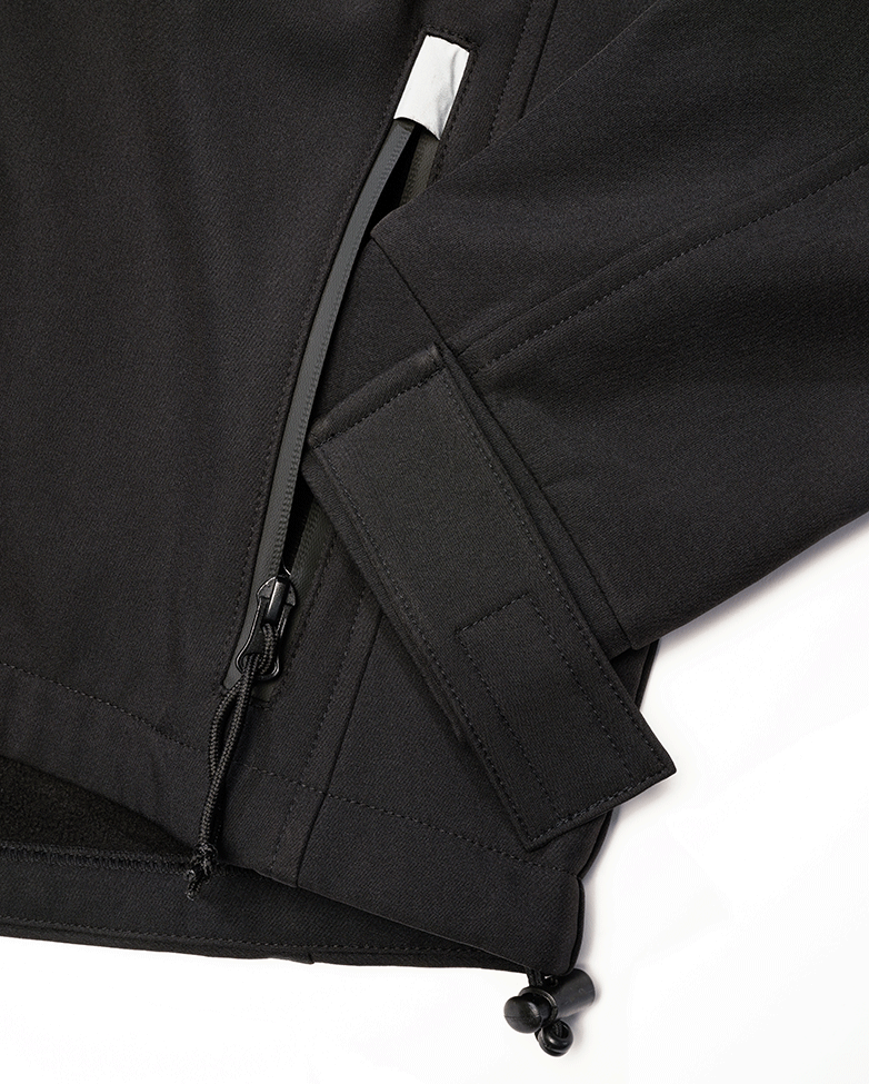 Schwarze Brandit Softshelljacke mit wasserdichten Reissverschlüssen und reflektierenden Details.