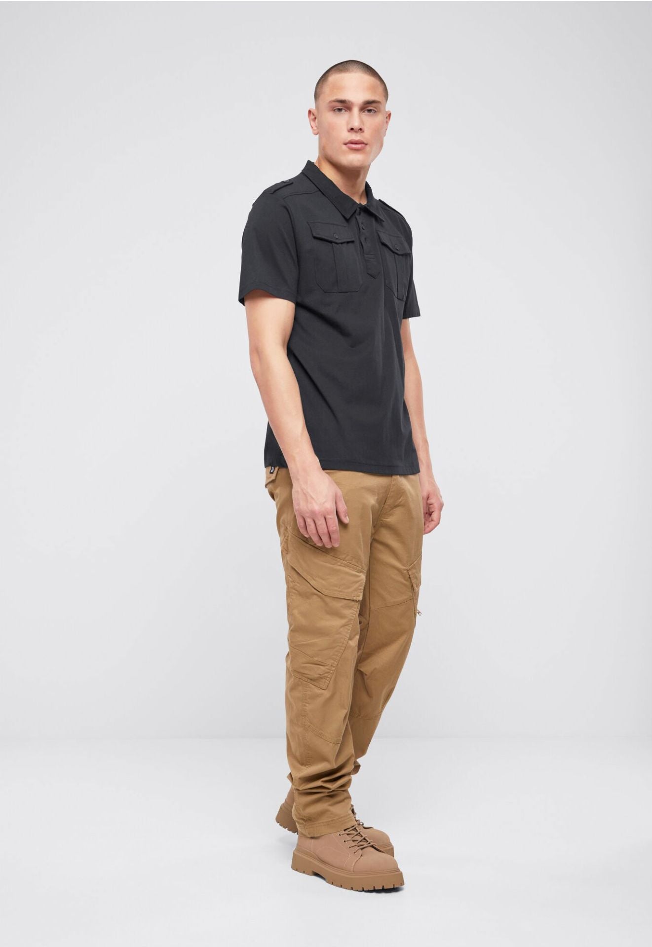 Schwarzes Brandit Kurzarm-Poloshirt aus weicher Baumwolle mit klassischem Schnitt, Polokragen und zwei Brusttaschen.