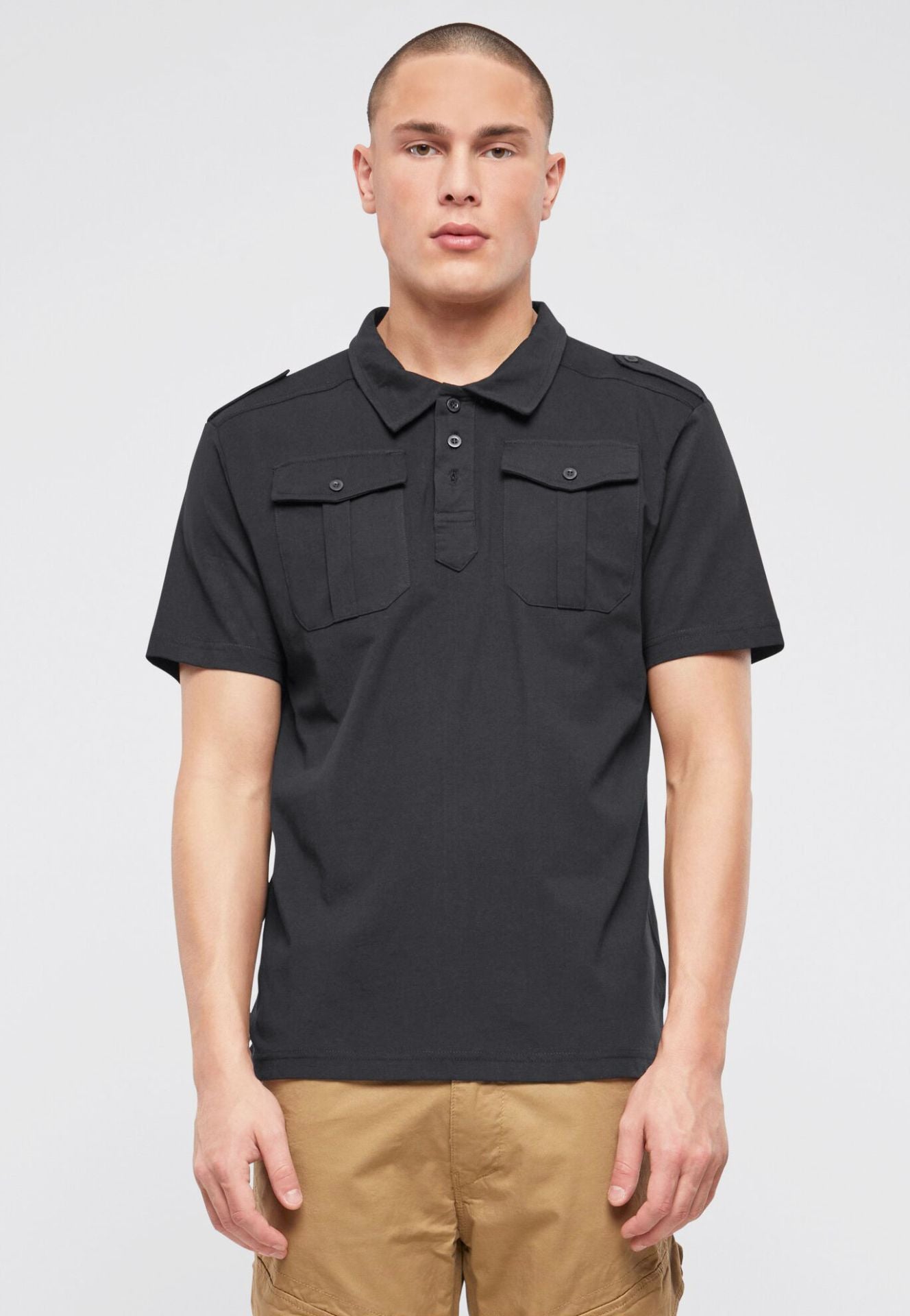 Schwarzes Brandit Kurzarm-Poloshirt aus weicher Baumwolle mit klassischem Schnitt, Polokragen und zwei Brusttaschen.