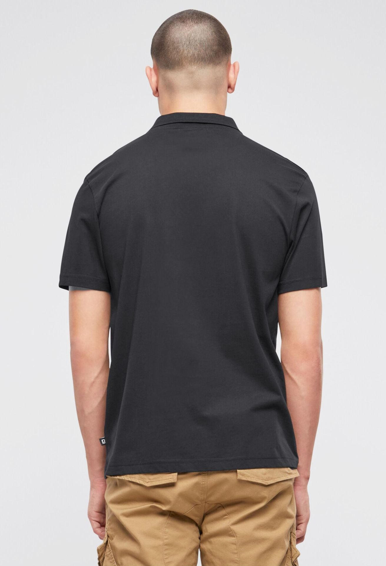 Schwarzes Brandit Kurzarm-Poloshirt aus weicher Baumwolle mit klassischem Schnitt, Polokragen und zwei Brusttaschen.