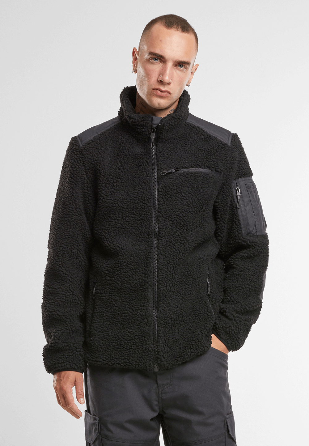 Brandit Teddyfleece Jacke in schwarz mit Ripstop-Einsaetzen, Reissverschlusstaschen, hohem Kragen und atmungsaktivem Meshfutter.