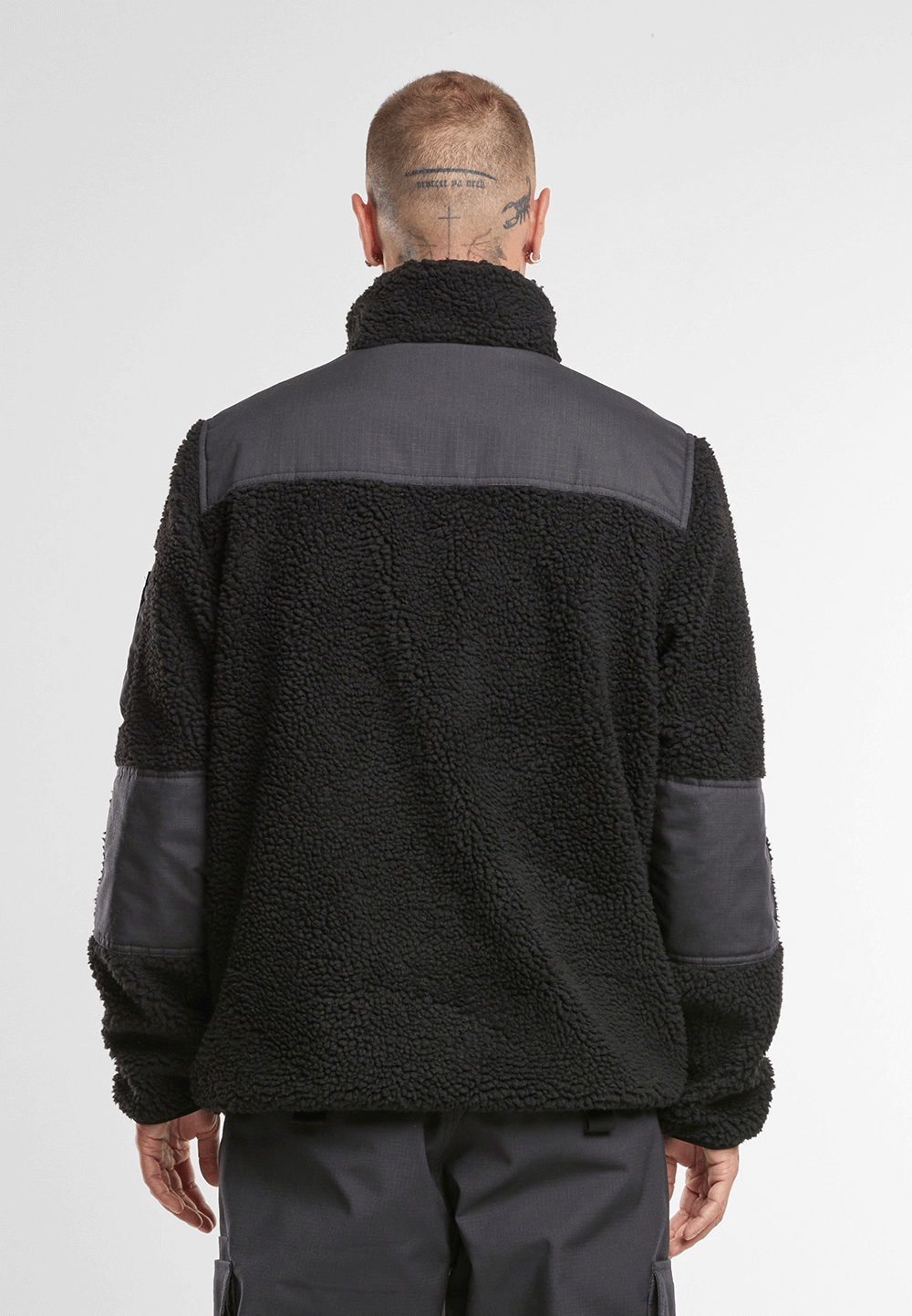 Brandit Teddyfleece Jacke in schwarz mit Ripstop-Einsaetzen, Reissverschlusstaschen, hohem Kragen und atmungsaktivem Meshfutter.