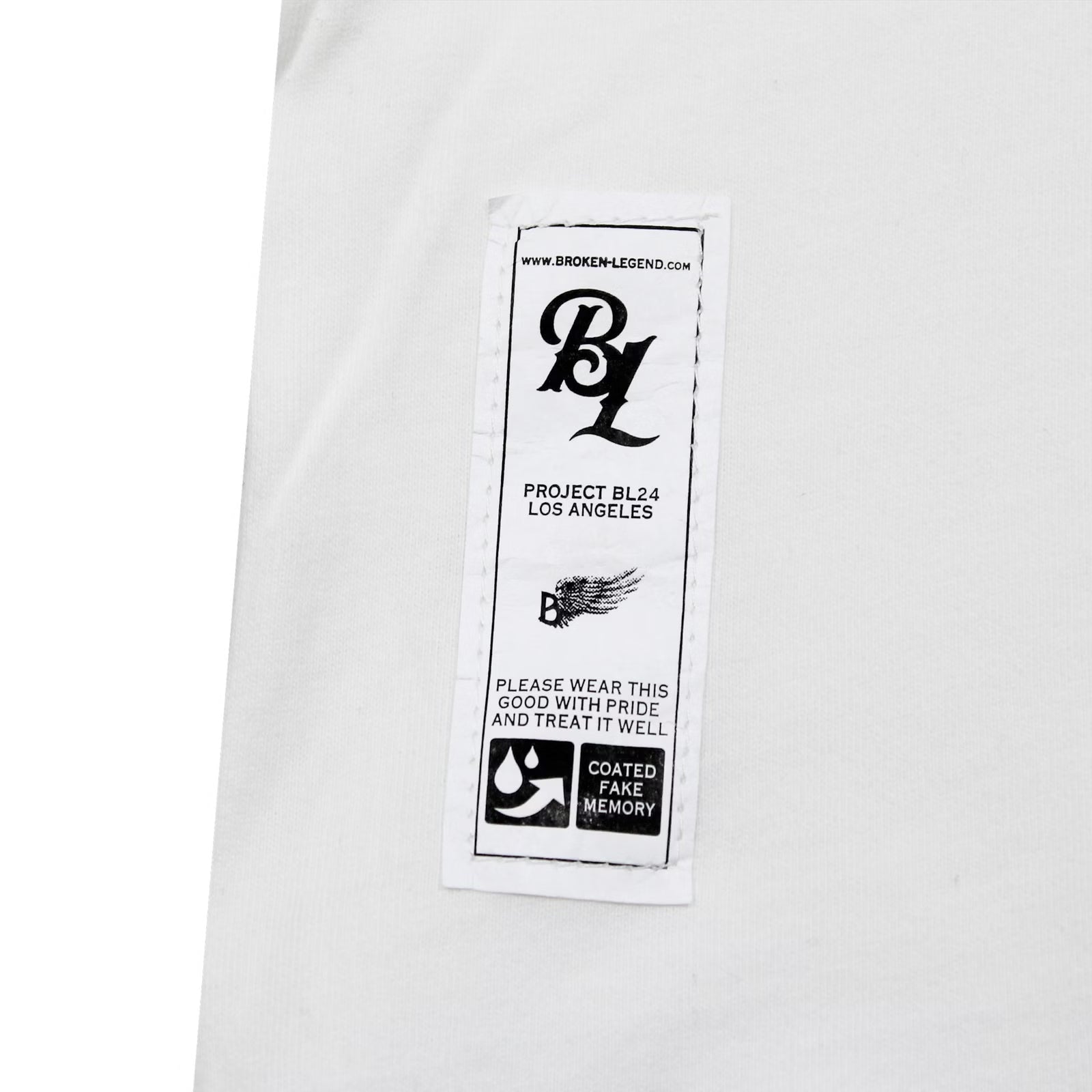 Detailaufnahme des Saum-Etiketts vom weissen Broken Legend Shirt