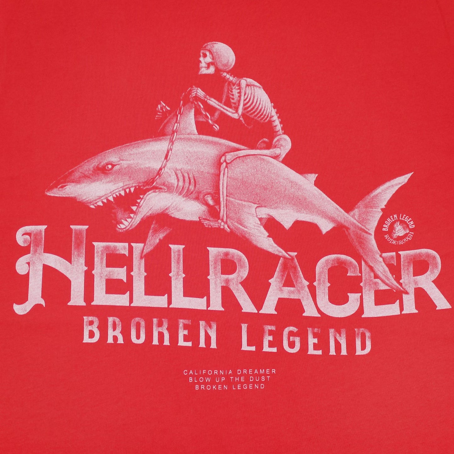 Detailaufnahme des Broken Legend Haifisch-Motivs auf roter Pima-Baumwolle – hochwertiger Siebdruck.