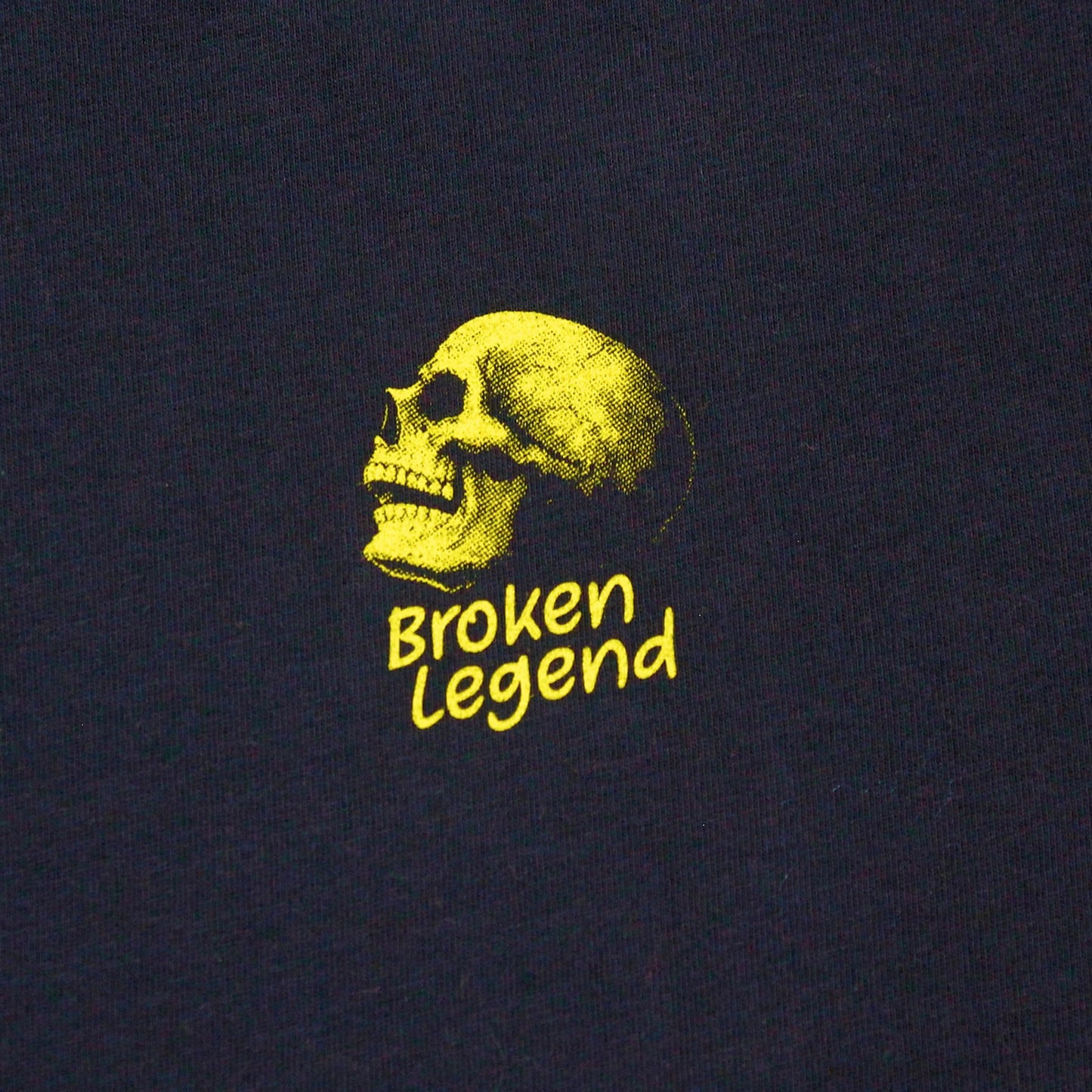Gelber Totenkopf-Print mit dem Broken Legend Marken-Schriftzug auf dem dunkelblauen T-Shirt.