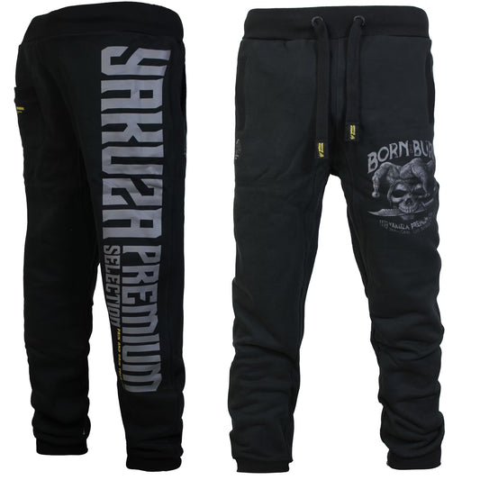 Yakuza Premium Herren Jogginghose in Schwarz mit grossem grauem Yakuza Premium Selection Schriftzug auf der Rückseite und Joker Harlekin Print auf dem linken Bein.