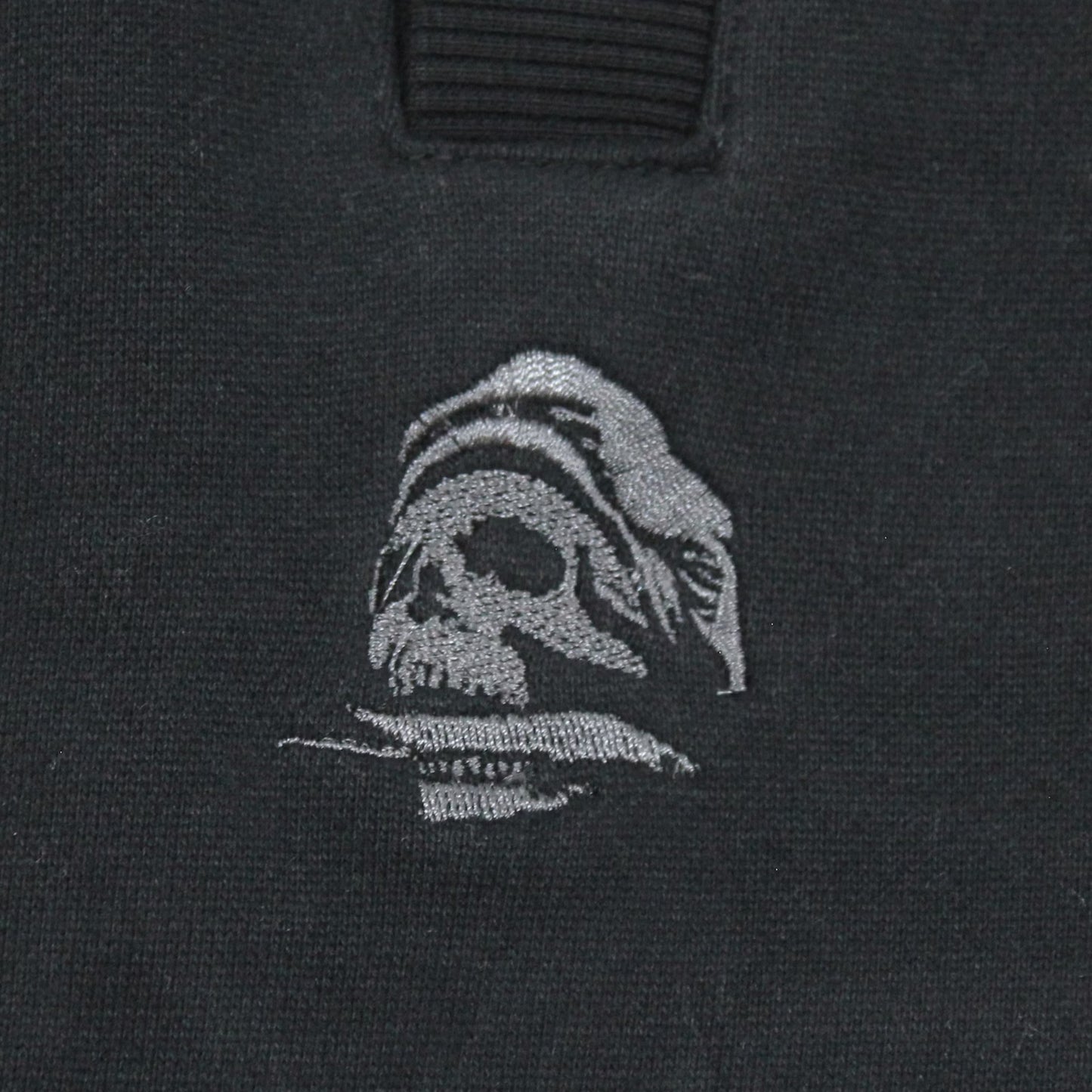 Yakuza Premium Herren Jogginghose Schwarz Detailansicht kleine Totenkopf-Stickerei in Grau auf der rechten Seite.