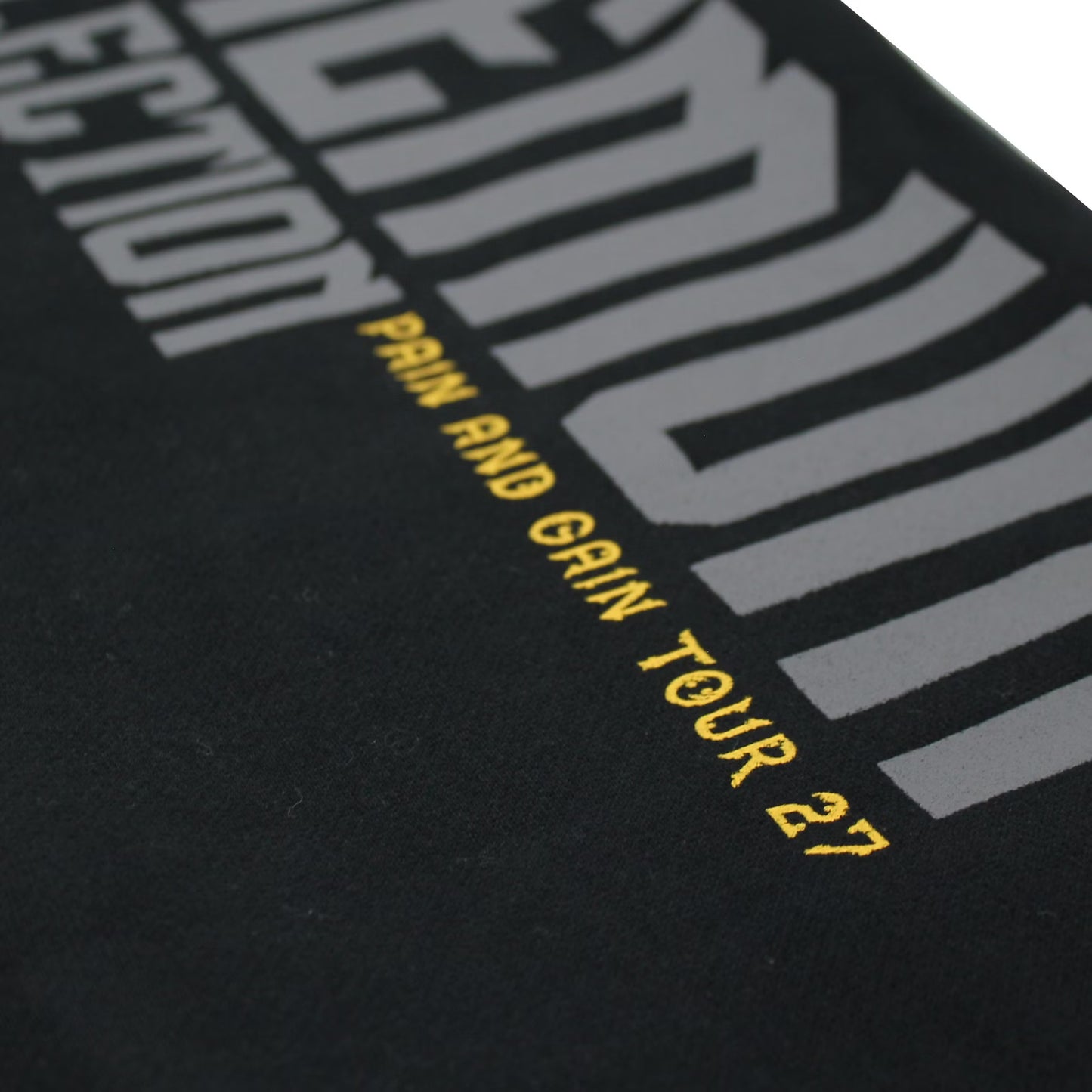 Yakuza Premium Herren Jogginghose Schwarz Detailansicht Print mit gelbem Pain and Gain Tour 27 Schriftzug.
