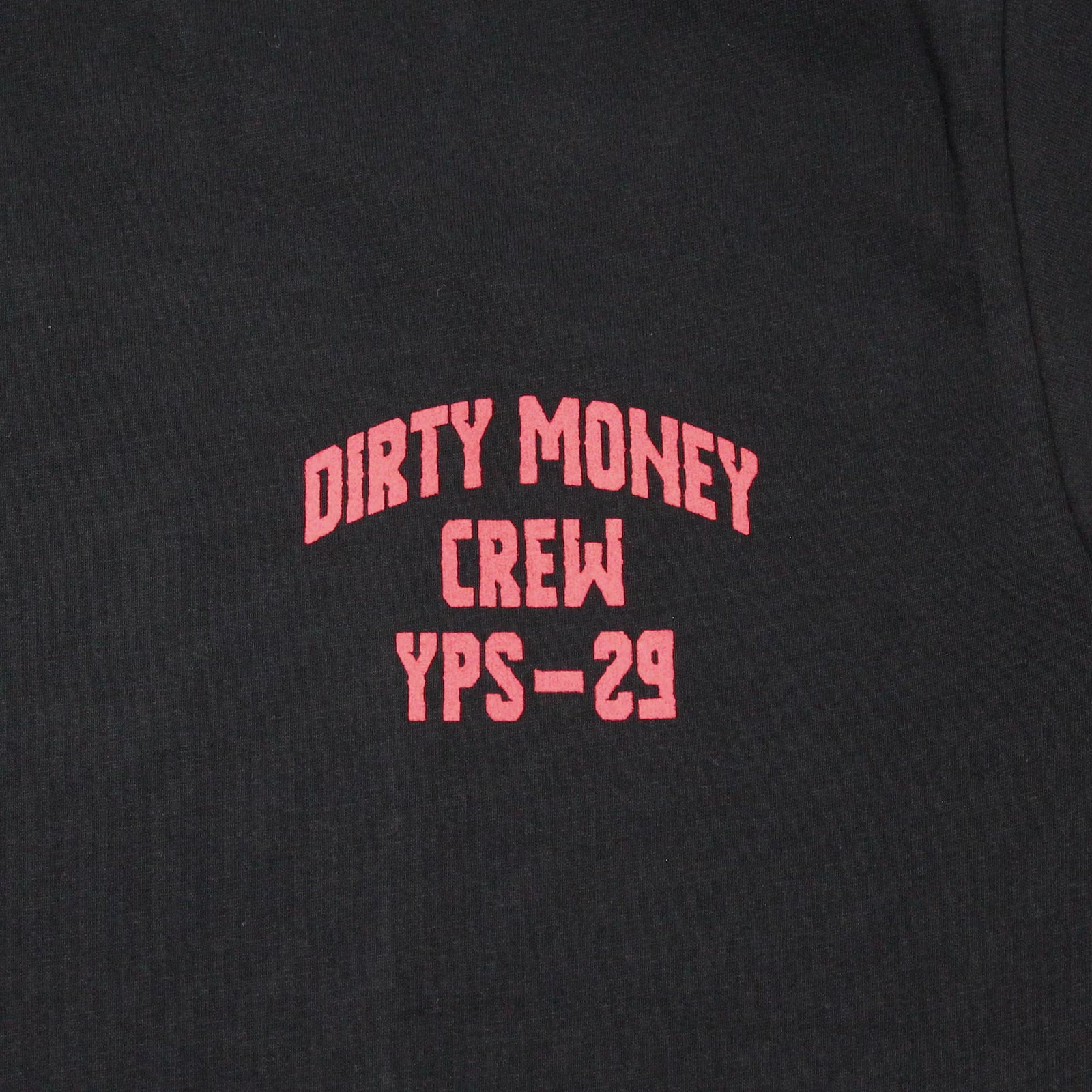 Nahaufnahme von rotem Dirty Money Crew Brustlogo auf schwarzem Yakuza Premium Shirt.
