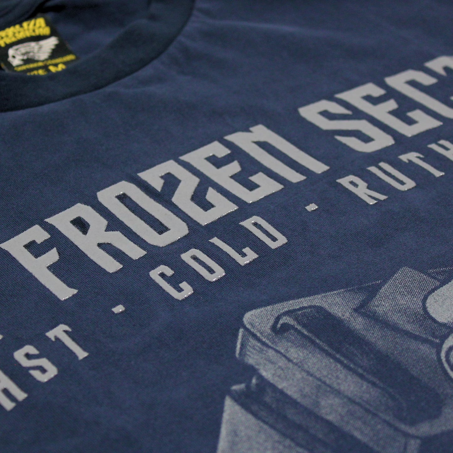 Nahaufnahme von gummiertem Frozen Section Schriftzug auf dunkelblauem Yakuza Premium T-Shirt.