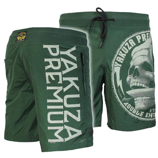 Dunkelolive Yakuza Premium Badeshorts für Herren mit Totenkopf-Print auf der Vorderseite und vertikalem Logo-Schriftzug auf der Rückseite.
