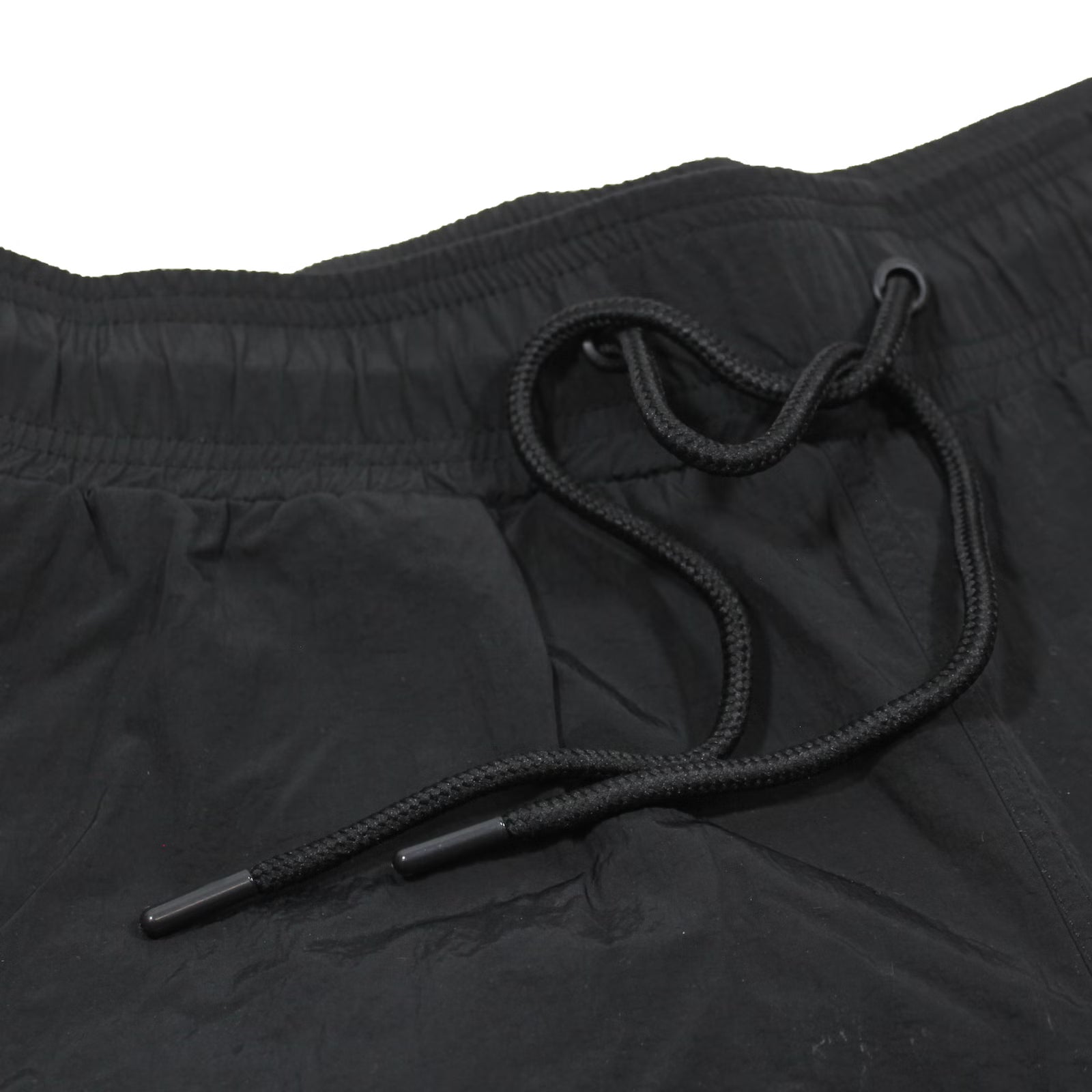 Detailansicht des elastischen Bunds und Kordelzugs der schwarzen Yakuza Premium Badeshorts.