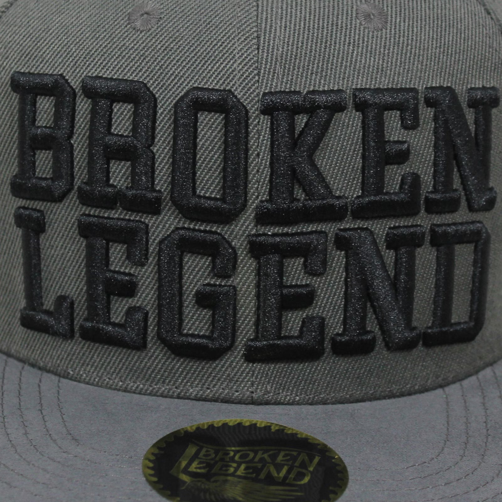 Dunkelgraue Broken Legend Snapback mit grossem 3D-Schriftzug und geradem Schild.
