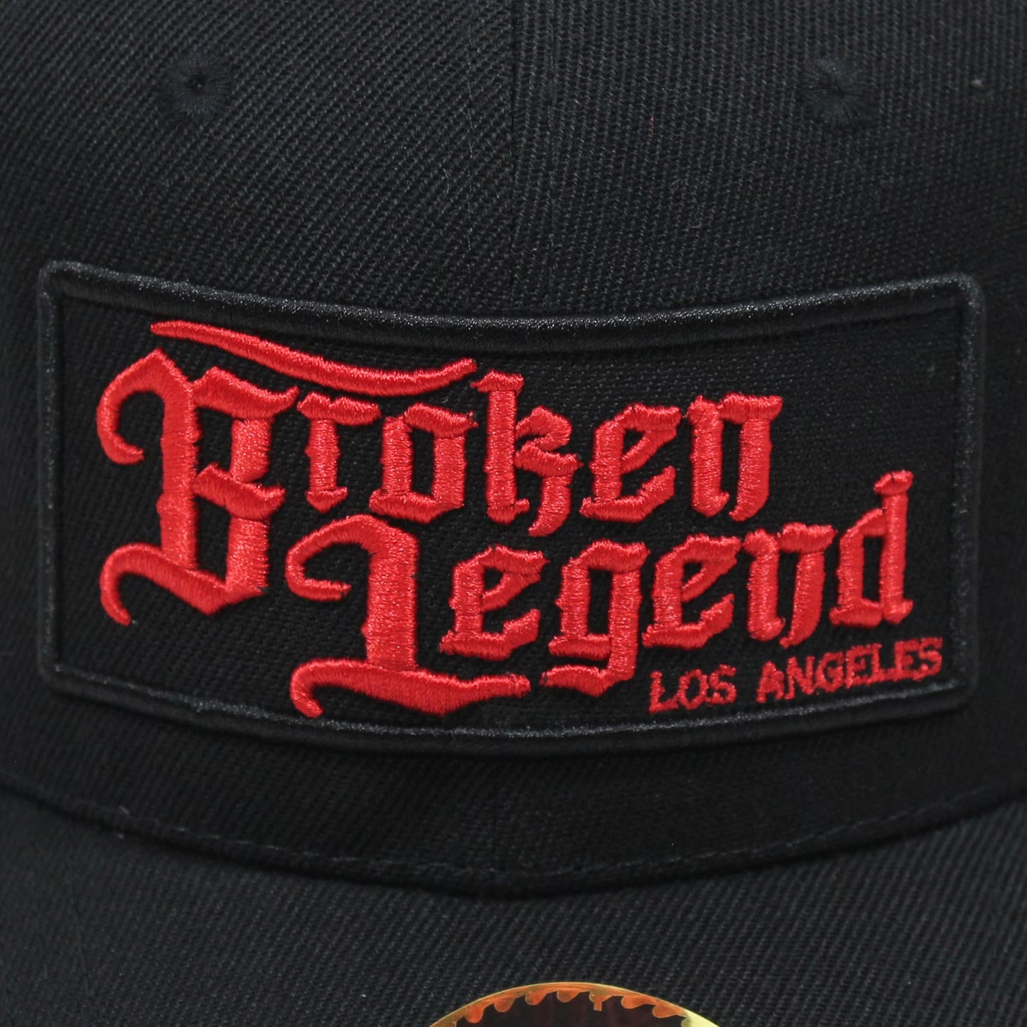 Schwarze Broken Legend Snapback mit gesticktem Front-Patch und gebogenem Schild.