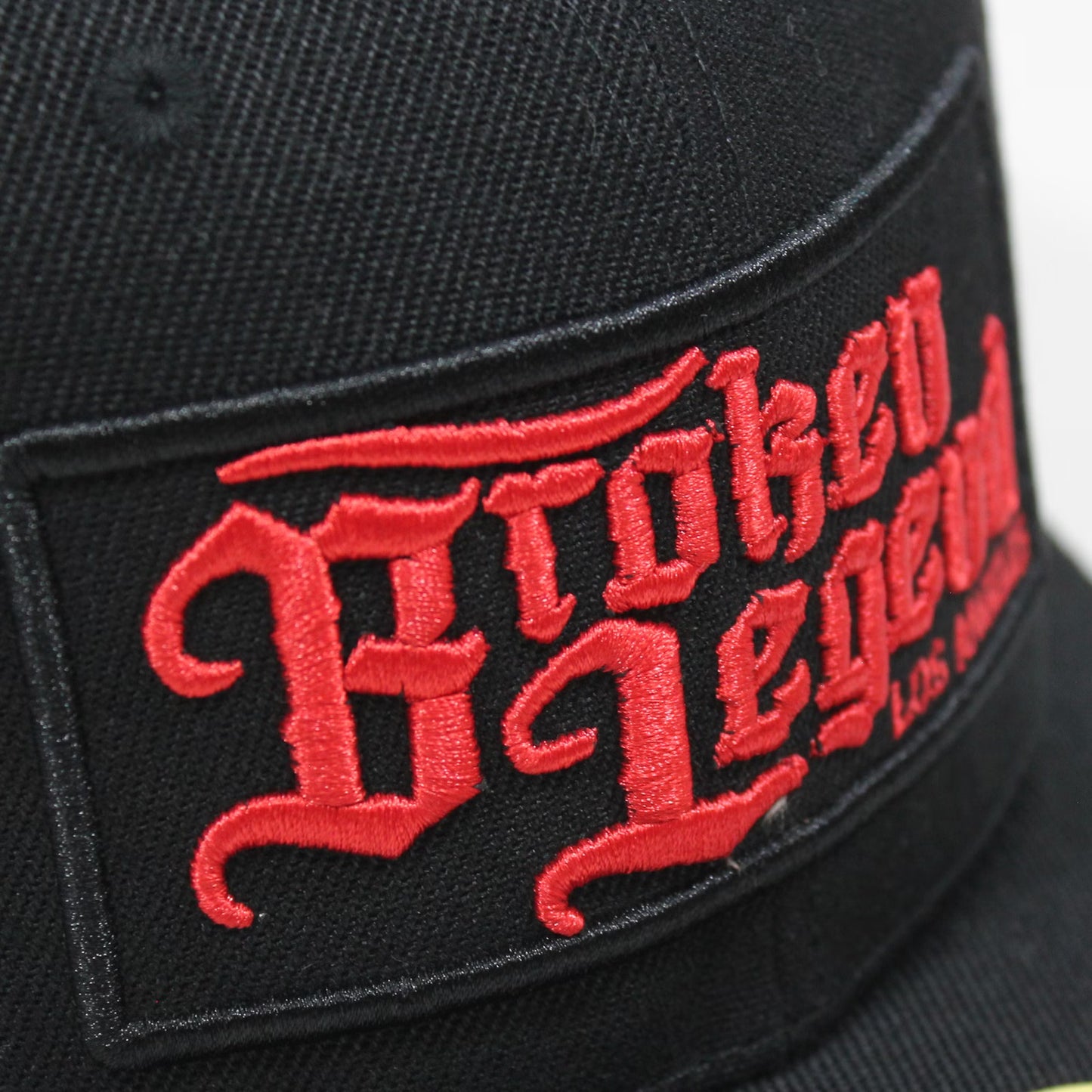 Schwarze Broken Legend Snapback mit gesticktem Front-Patch und gebogenem Schild.