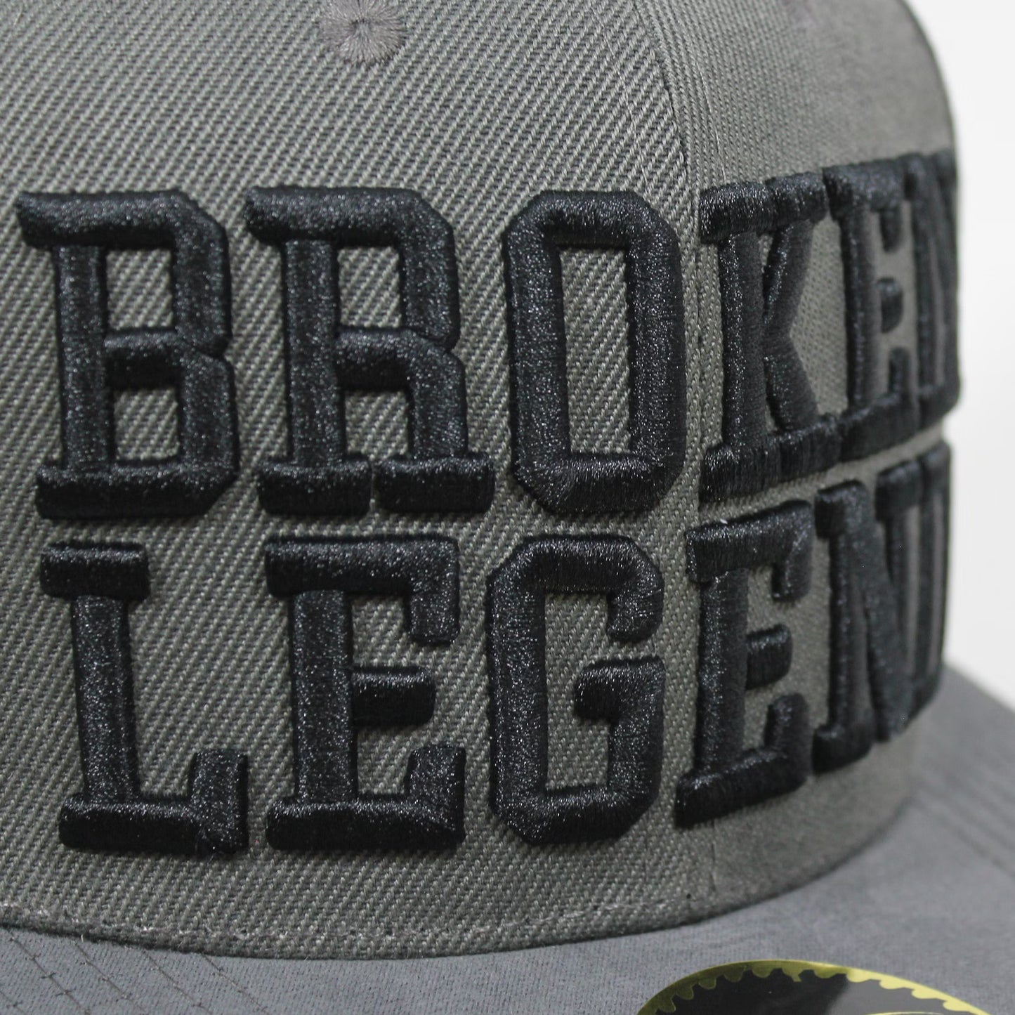 Dunkelgraue Broken Legend Snapback mit grossem 3D-Schriftzug und geradem Schild.