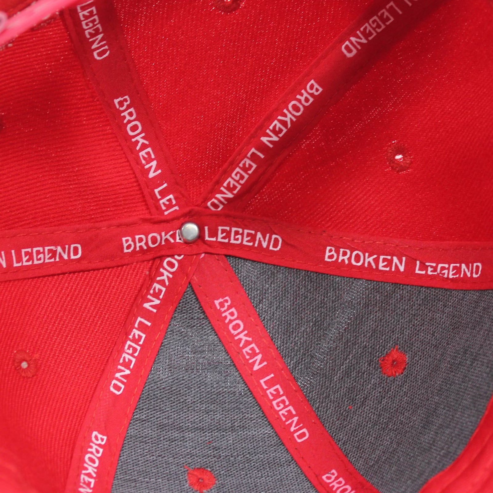 Innenansicht der roten Broken Legend Snapback mit weissem Branding-Tape und Label.